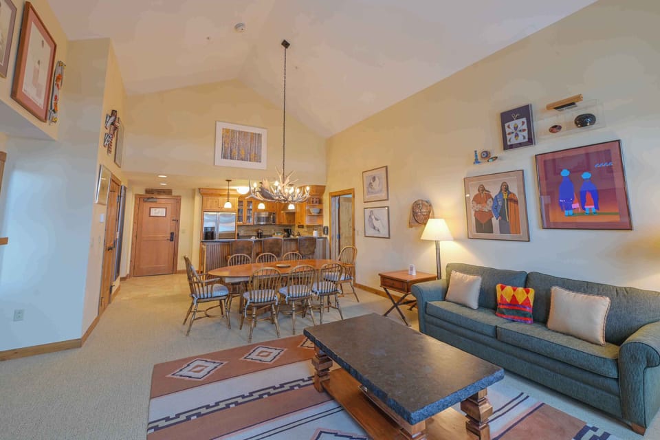 With a plush sofa and rustic dining table, this elegant space is perfect for entertaining while showcasing unique art pieces that reflect the surrounding nature.