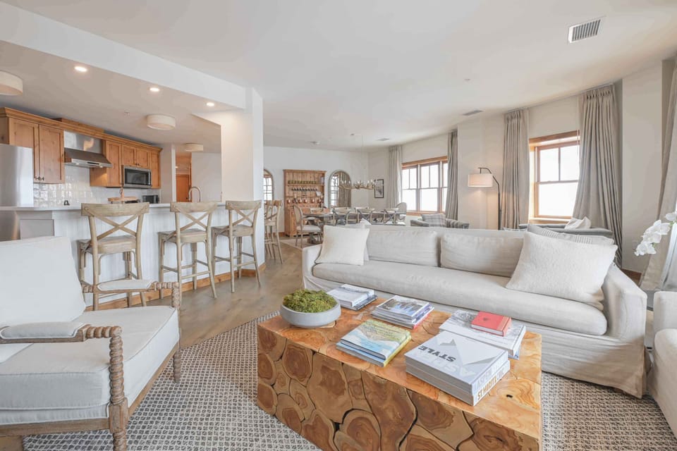 An inviting open living area connects the kitchen and dining space, highlighted by stylish furnishings and warm natural light.