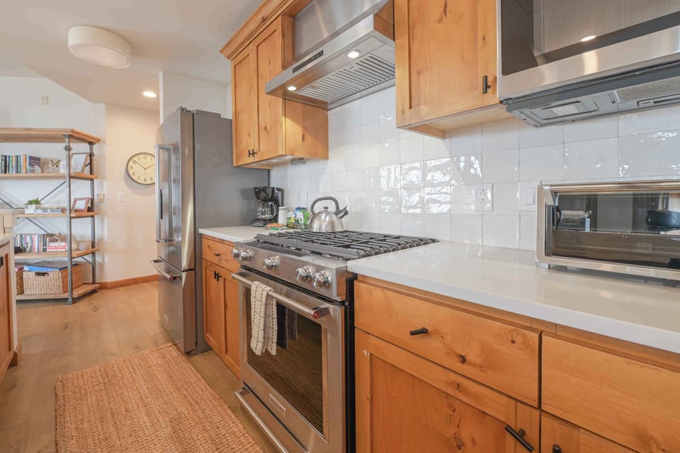 This modern kitchen is fully equipped with high-end appliances and ample storage, providing a perfect space for culinary creations.