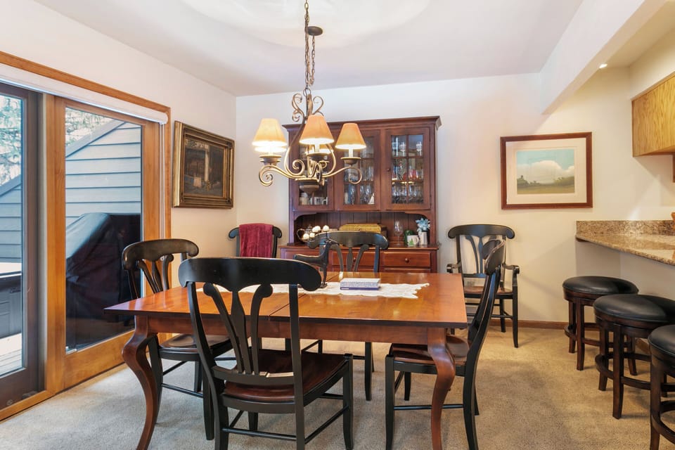 Gather around the warm wooden dining table for memorable meals with your group, featuring elegant furnishings and a cozy atmosphere perfect for sharing stories.