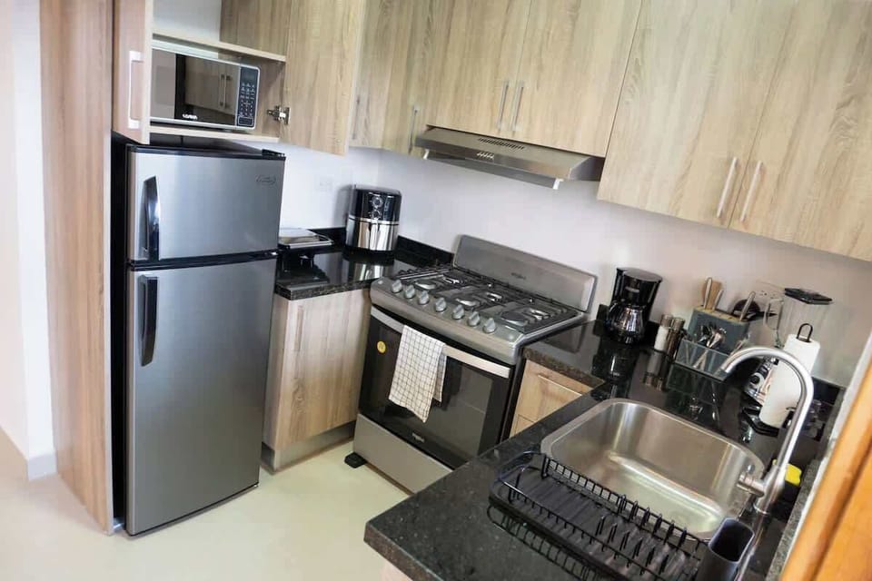 - Fully equipped kitchen with stove oven fridge coffee maker and cookware
- Modern kitchen setup for home meals long stays and family travel
- Clean functional layout with counter space utensils and appliances ready
