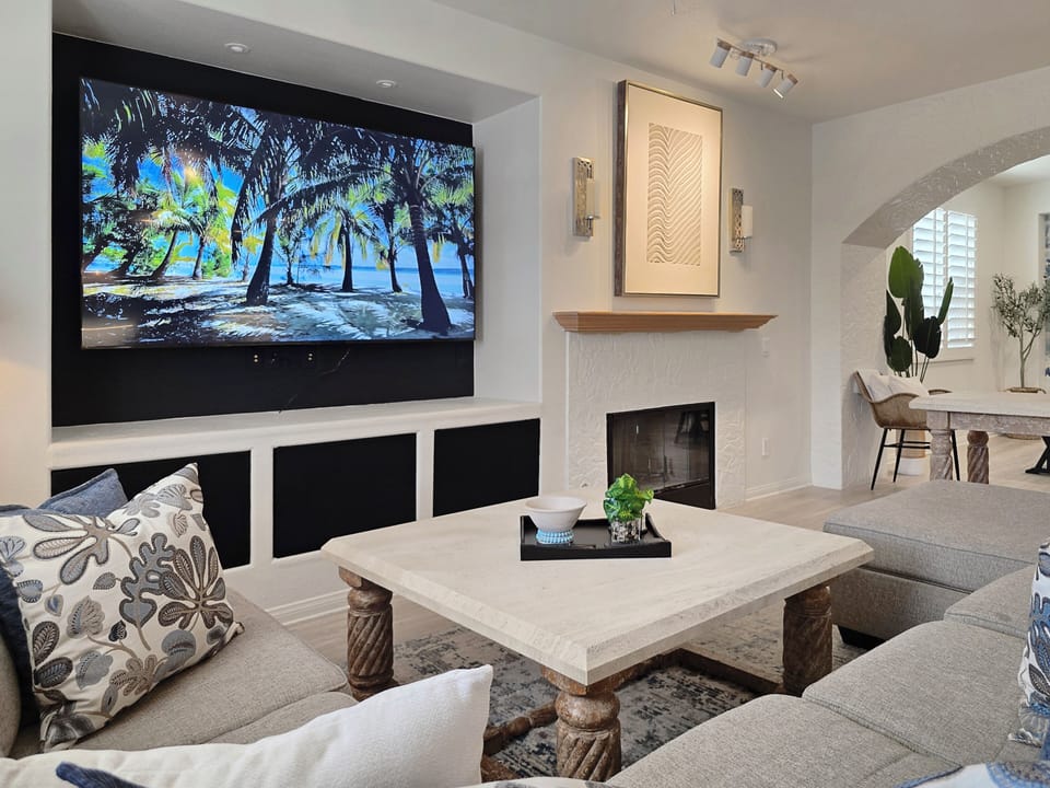 Comfortable sectional sofa with chaise lounge, coffee table and 87" 4K Smart TV.