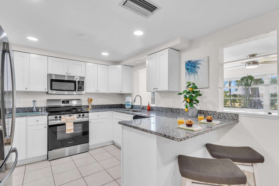 Modern appliances, quartz counters, and fully stocked for cooking.