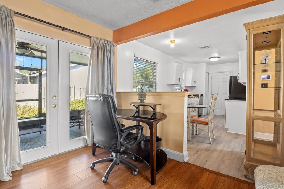 Office desk located within living room near the kitchen.