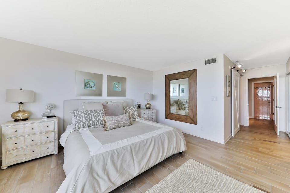 Spacious coastal bedroom with plush bedding, calming décor, and a serene layout. Designed for comfort and relaxation, it's the ideal retreat to unwind and enjoy a peaceful beach stay.