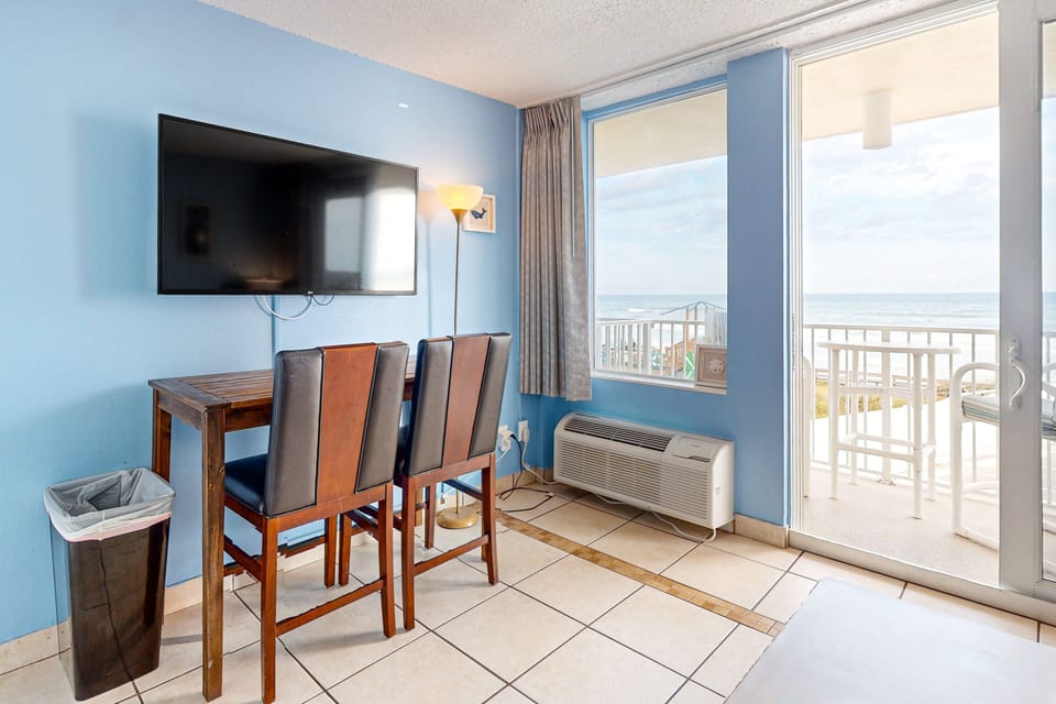 Dine and relax during your beach stay in this oceanview dining area featuring a mounted TV and direct balcony access. Enjoy coastal breezes and scenic beach views just steps from your table.