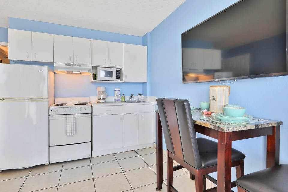 Enjoy easy meals during your beach stay in this bright coastal kitchen with full appliances and a cozy dining area. Ideal for relaxing breakfasts or casual dinners after a fun-filled day at the beach.