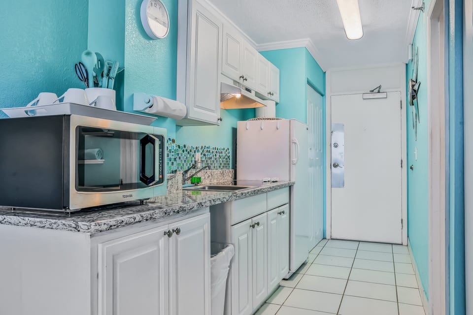 Bright beach stay kitchenette with modern appliances, coastal colors, and everything needed for light meals. Perfect for fueling up before beach days or enjoying relaxed beachfront vacation dining indoors.