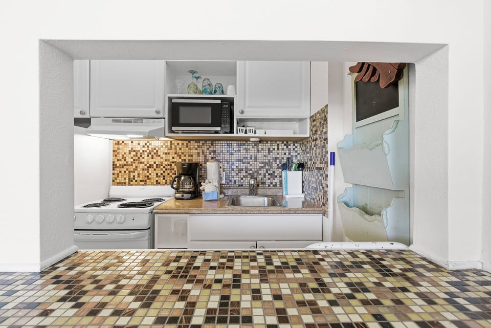Enjoy the convenience of this fully equipped kitchenette during your beach stay. Perfect for preparing meals and snacks, it features essential appliances and coastal charm to complement your seaside getaway.