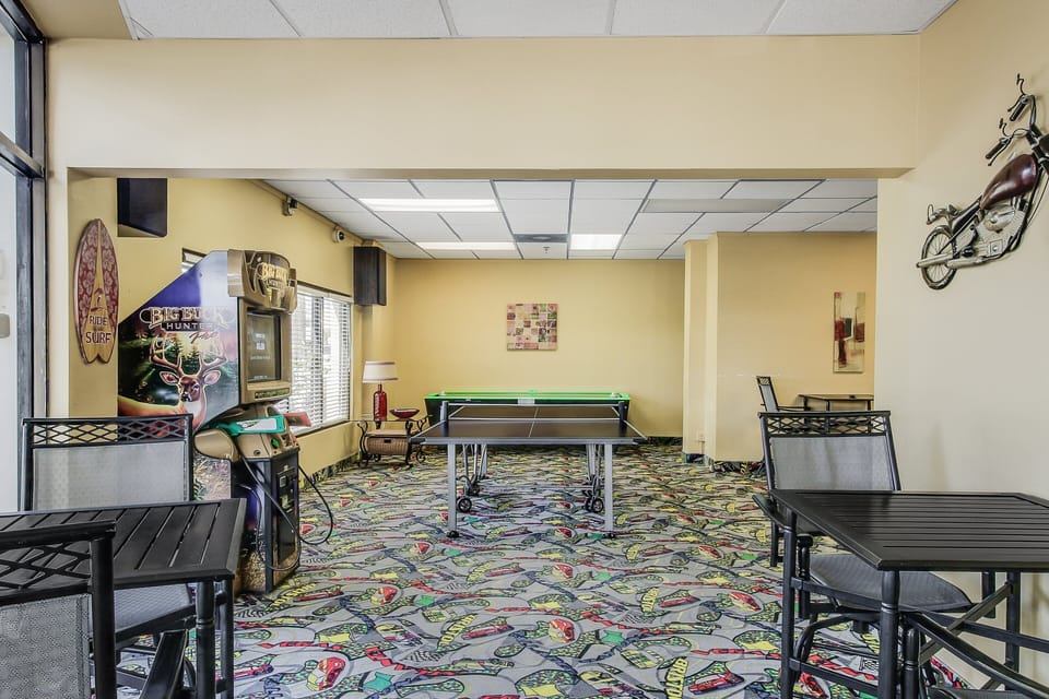 Enjoy extra entertainment during your beach stay in this recreation room with arcade games, table tennis, and casual seating—perfect for relaxing and having fun beyond the sand and surf.