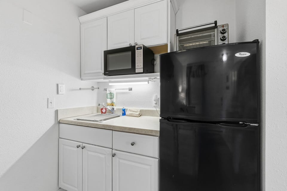 This clean, compact kitchenette is perfect for your beach stay, featuring a full-size refrigerator, microwave, toaster oven, and sink. Ideal for quick meals and snacks before heading out to enjoy the beach and ocean nearby.