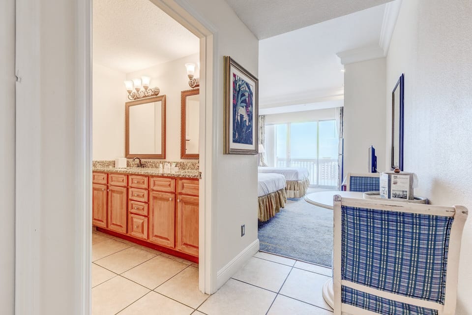 Step into this sunny beach stay retreat featuring a spacious double-sink vanity and welcoming bedroom beyond. Perfect for relaxing after a day by the shore.