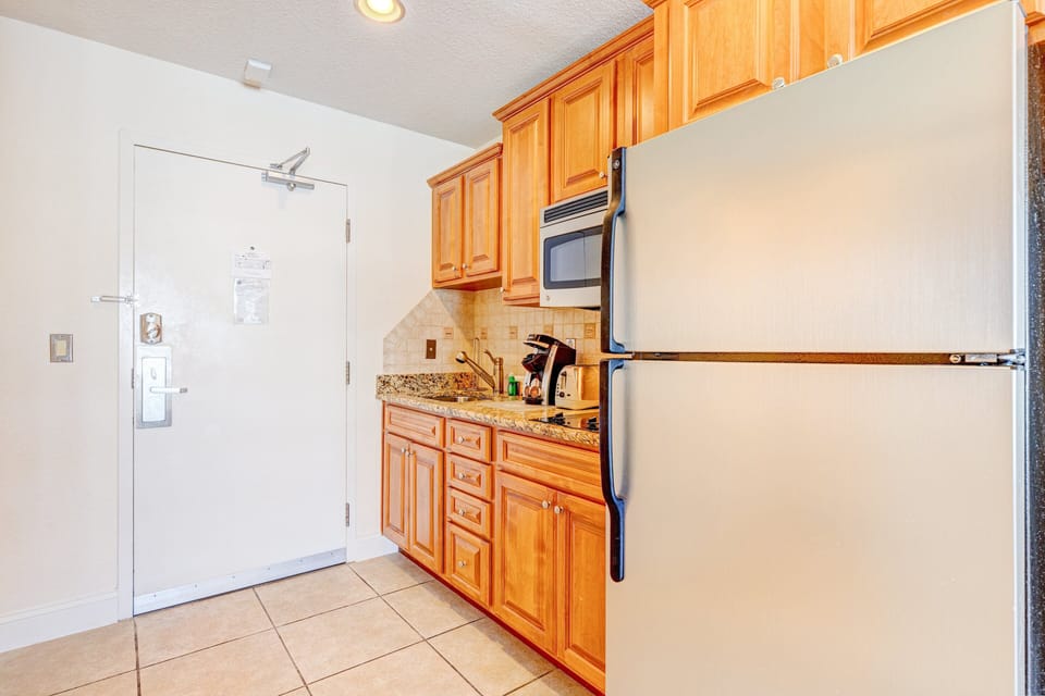 Convenient kitchenette with full fridge, microwave, and granite counters—perfect for preparing quick meals during your beach stay. Enjoy all the essentials just steps from the shore.
