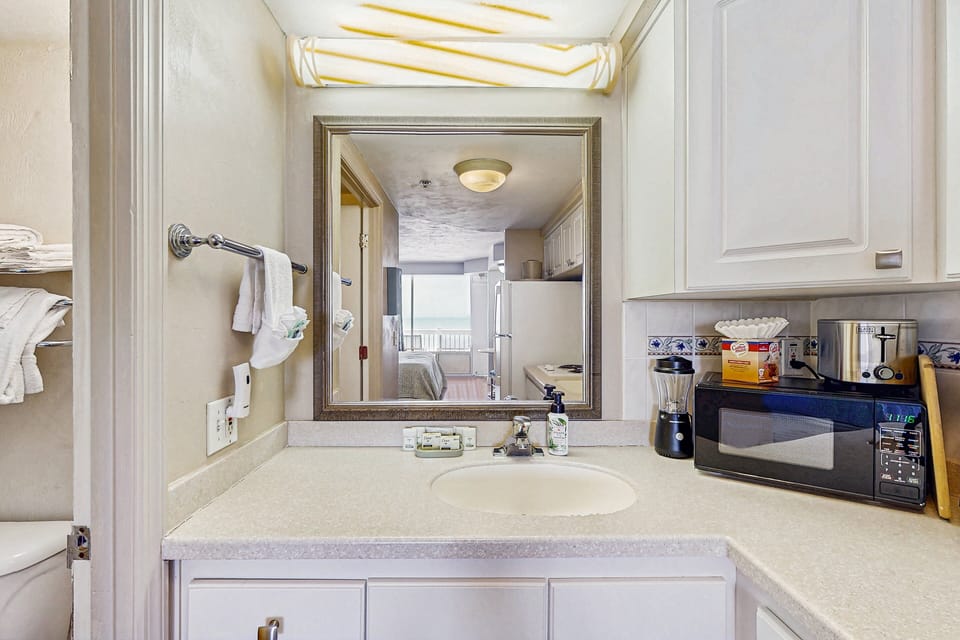 Clean, well-lit vanity area offering ample counter space and everyday essentials. Designed for comfort and convenience, it's the perfect spot to refresh and recharge during your relaxing beach stay.