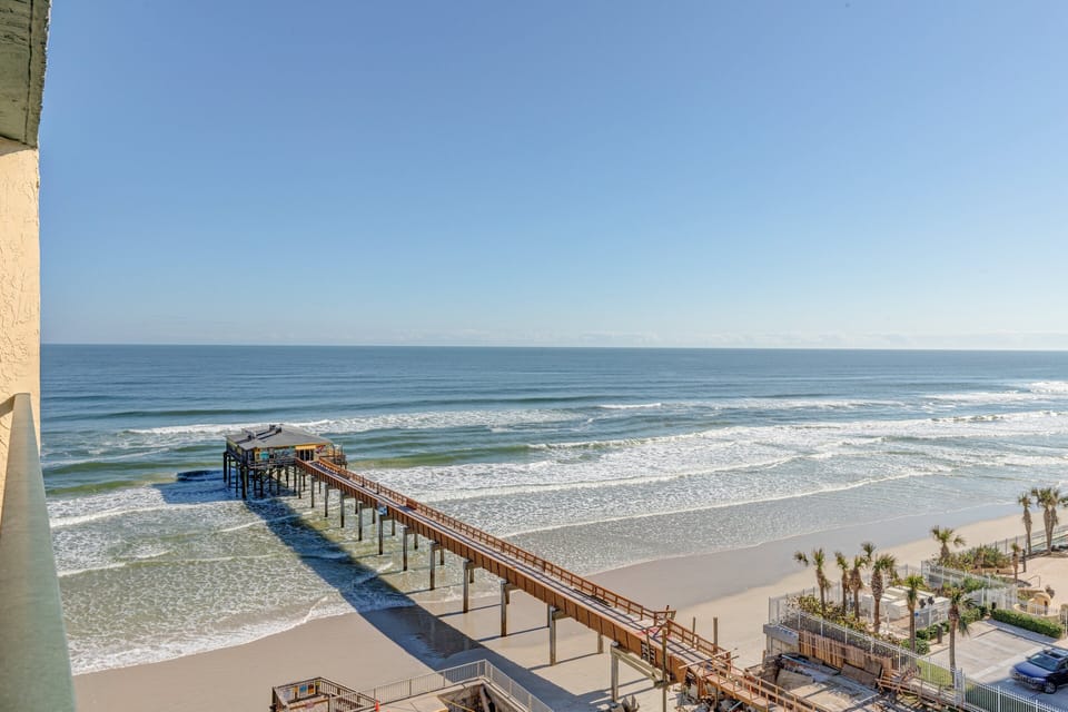 Enjoy breathtaking views of the shoreline and nearby pier stretching into the Atlantic. Watch waves roll in and soak up coastal beauty—this stunning oceanfront scene perfectly captures the magic of a relaxing beach stay.