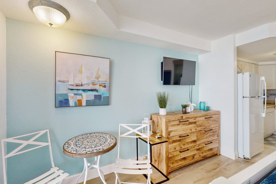 Bright, beach-inspired dining corner with stylish décor, a cozy table set, and coastal artwork. A perfect spot to enjoy meals or coffee during your relaxing beach stay.