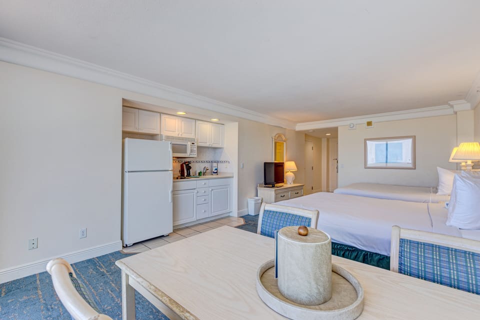 Spacious beachfront studio featuring a full kitchenette, two comfy beds, and a dining area with ocean views—perfect for a relaxed and convenient beach stay.