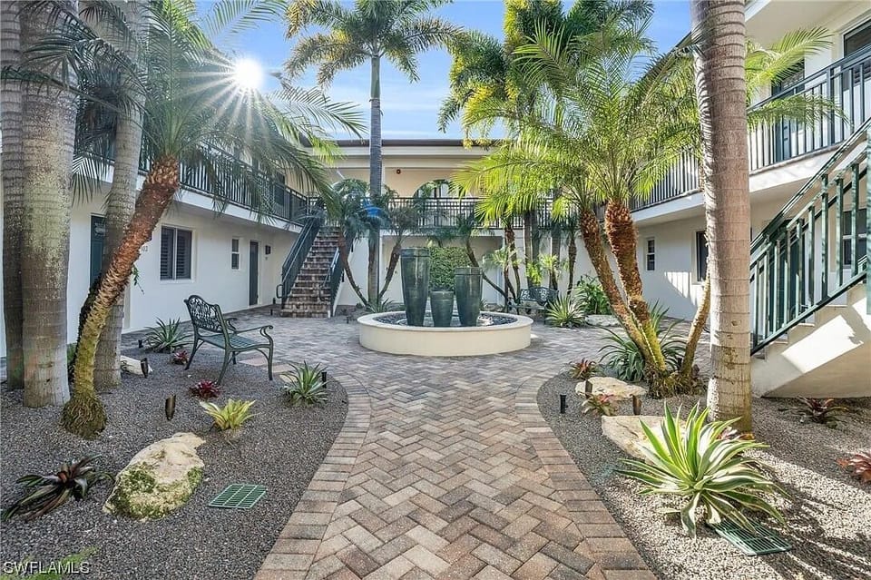 Front courtyard and building exterior with tropical landscaping