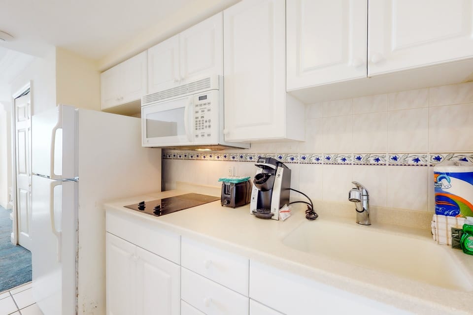 Convenient kitchenette with essential appliances and plenty of storage—perfect for prepping quick meals during your beach stay. Clean, bright, and steps from the ocean vibes.