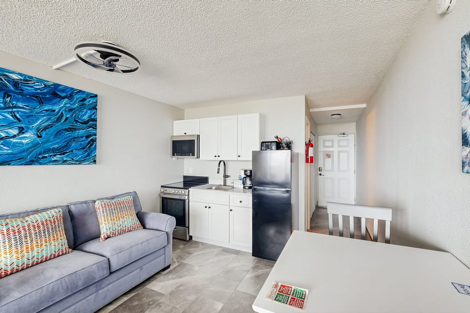 Enjoy a relaxed beach stay in this modern beachfront living area with sleeper sofa, dining space, and full kitchenette. Perfect for coastal getaways, offering comfort and convenience just steps from the beach.