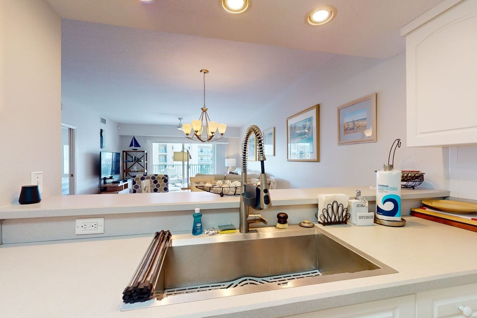Enjoy easy beach living in this open-concept kitchen overlooking the living space and balcony. Perfect for your beach stay, it blends coastal style with modern convenience for relaxed meals and gatherings.
