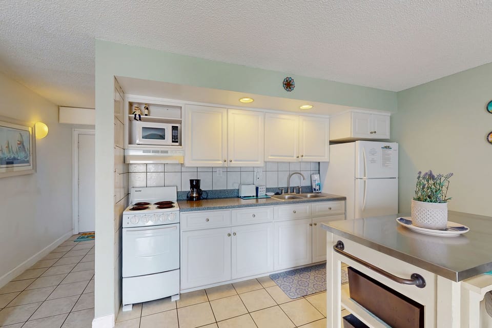 This bright, fully equipped kitchen makes your beach stay effortless, featuring ample counter space, modern appliances, and a clean coastal feel—perfect for preparing meals after a day at the beach.