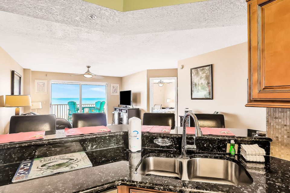 Experience the perfect beach stay in this beachfront vacation rental featuring a modern kitchen, granite counters, and open living space with direct access to a private balcony overlooking the ocean. Steps from the sand and surf.