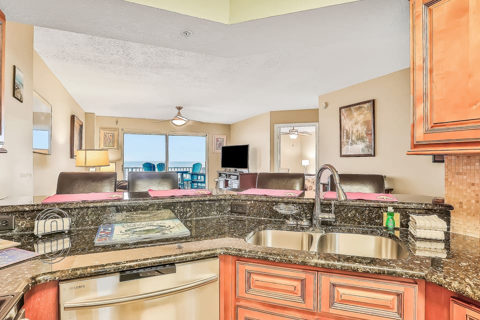 This oceanview vacation rental features a fully equipped kitchen, granite countertops, and open-concept living space leading to a private balcony. Perfect for a relaxing beach stay just steps from the sand and surf.