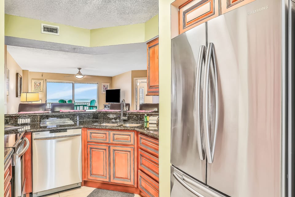 This beachfront vacation rental features stainless steel appliances, granite countertops, and an open layout flowing to a private balcony with ocean views. Ideal for a relaxing beach stay just steps from the sand.