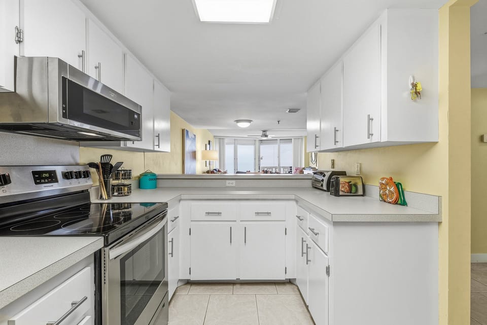 Bright, fully equipped kitchen with modern appliances, ample counter space, and an open view to the living area. Ideal for preparing meals and snacks during your comfortable and carefree beach stay.