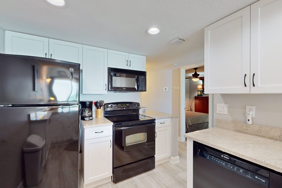 Bright, updated kitchen featuring sleek appliances, ample counter space, and everything you need to prepare meals during your relaxing beach stay.