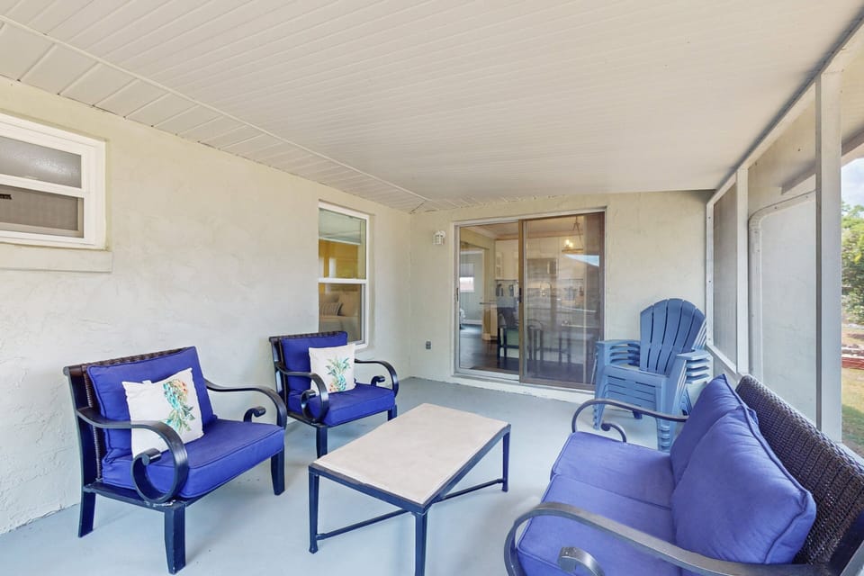 Relax in this breezy screened-in patio featuring comfy seating—an ideal spot to unwind after a fun-filled beach day or morning coffee before heading to the shore.