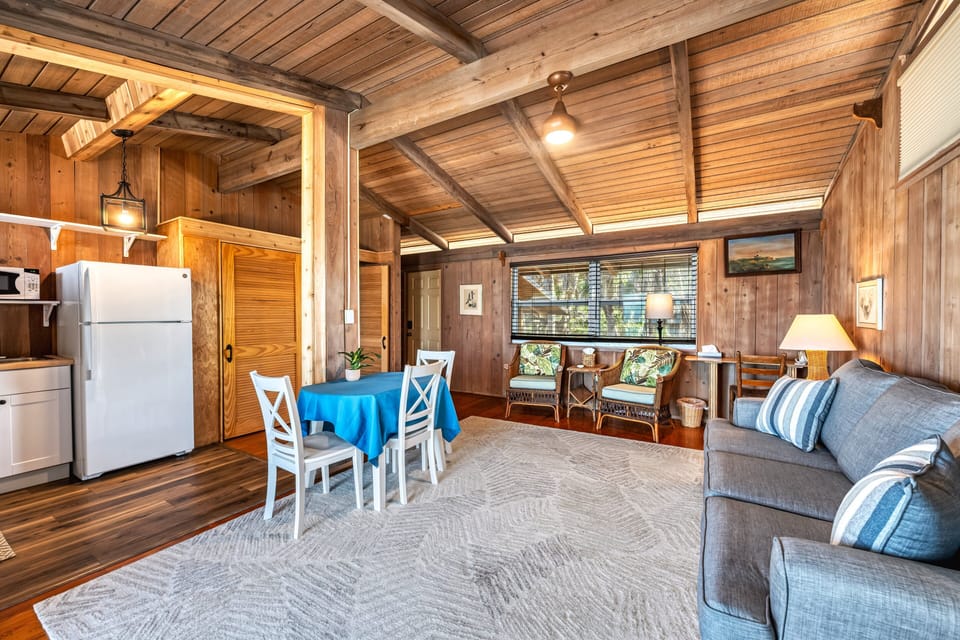 The open living and dining area feels airy and bright, with sunlight streaming through large windows toward Gulf views.