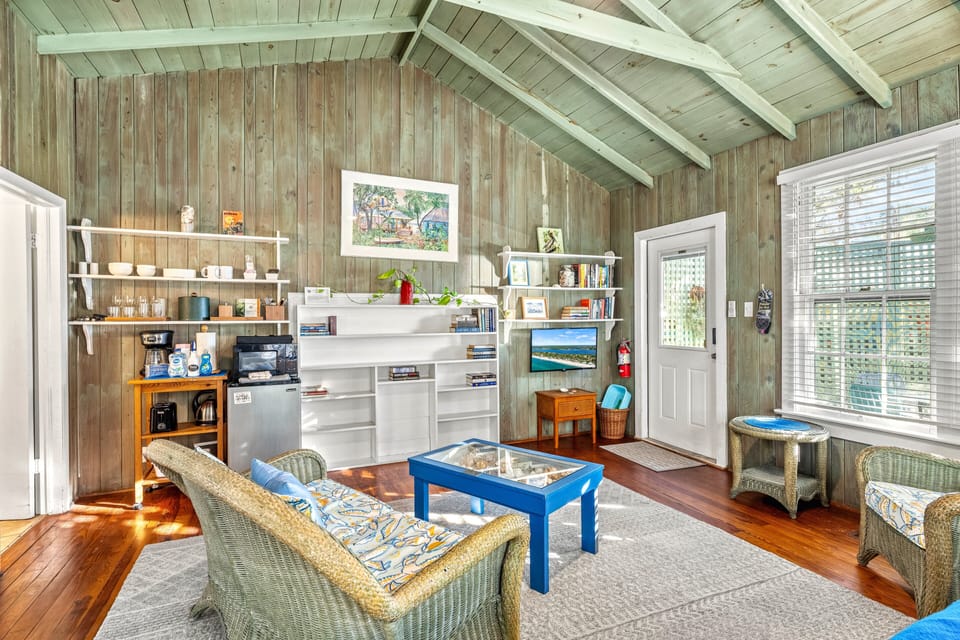 Cathedral ceilings draw the eye upward, while the living area's cozy seating and warm wood tones create a serene, airy space.