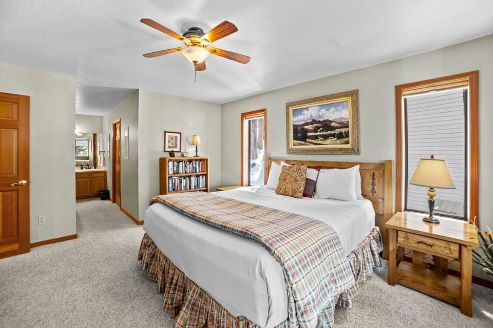 A beautifully appointed bedroom is complemented by natural light streaming through multiple windows, offering a serene retreat for guests.