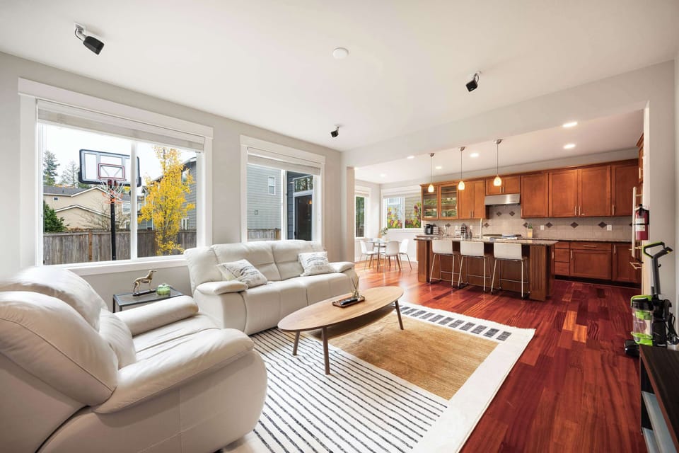 Sun-filled living area with cozy seating and views of the backyard.