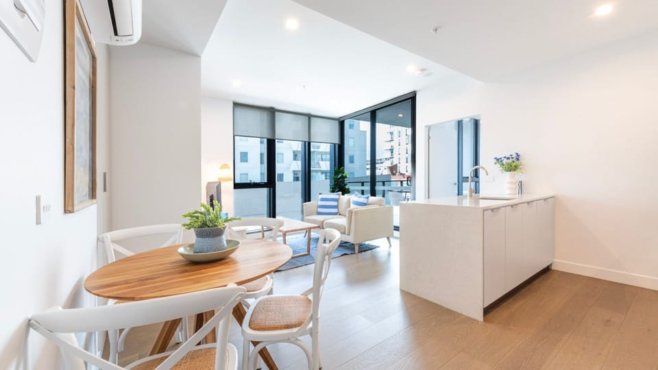 Dining area bathed in sunlight, seamlessly connecting to the kitchen.