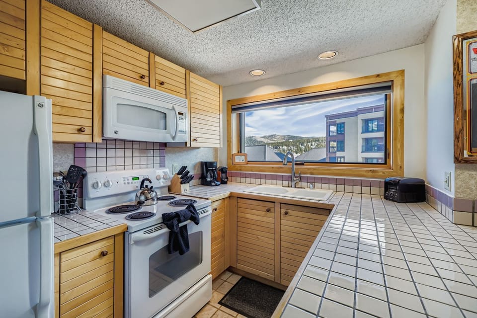 Your fully equipped kitchen features modern appliances, ample counter space, and a large window overlooking the surrounding area - perfect for preparing meals during your stay.