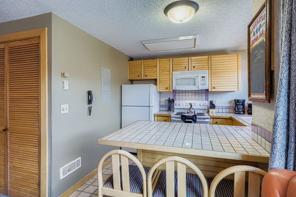 Your fully equipped kitchen features everything you need to prepare meals, with a breakfast bar perfect for casual dining and morning coffee.