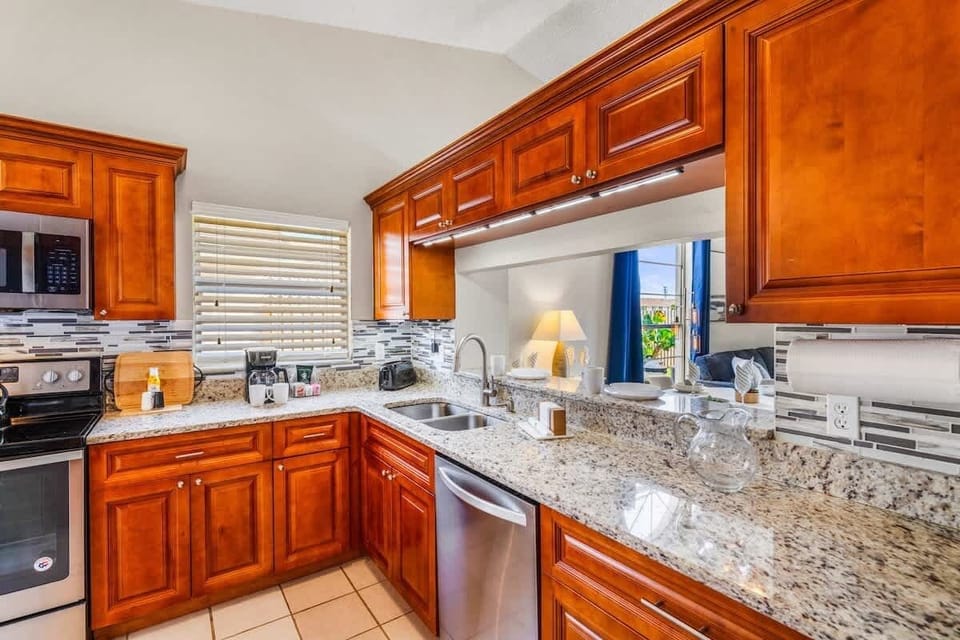 A complete kitchen with stove, oven, microwave, dishwasher, refrigerator, coffee maker, and hot water kettle—ideal for preparing meals during extended stays.