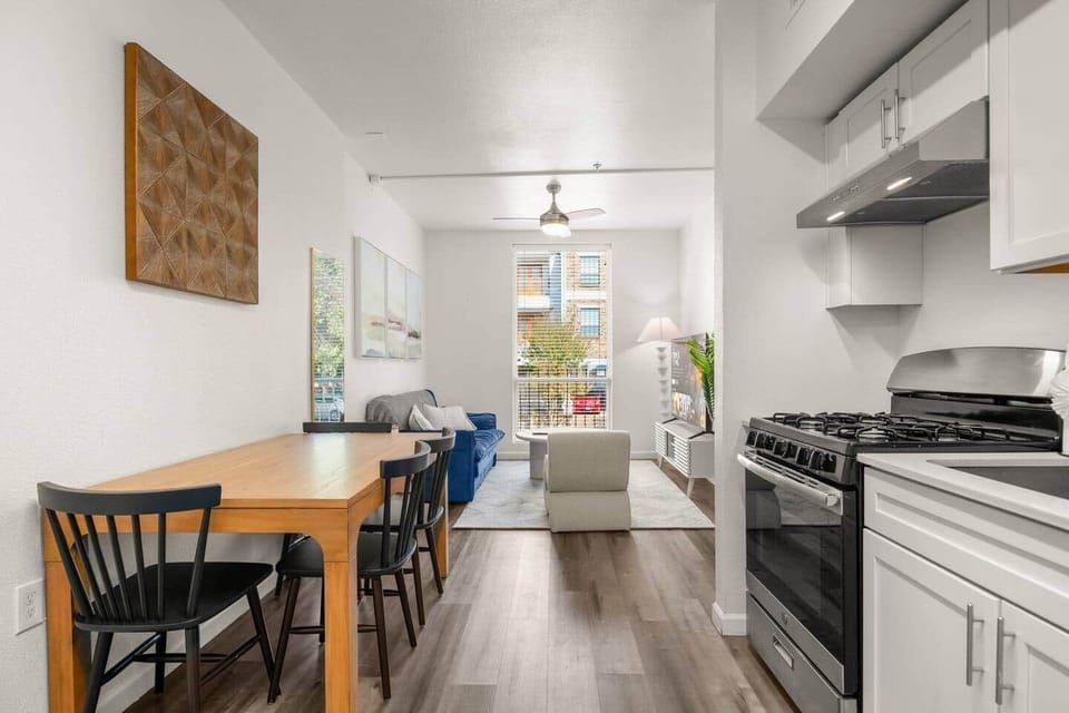 Fully equipped kitchen with gas range, dishwasher, and coffee setup opens to a bright dining and lounge area. Cook, connect, and recharge in the heart of West Campus.