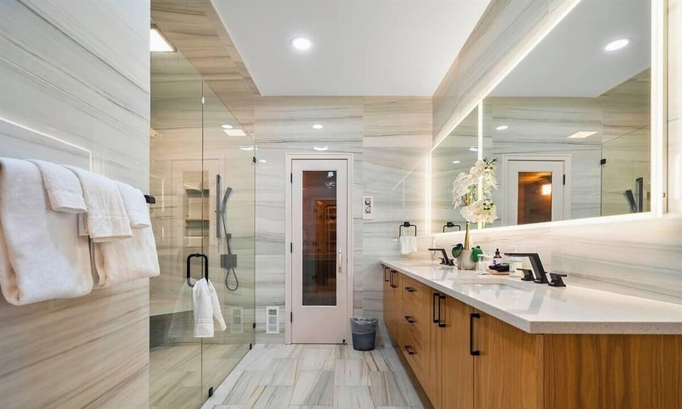 Luxury bathroom with dual vanities and walk-in shower.