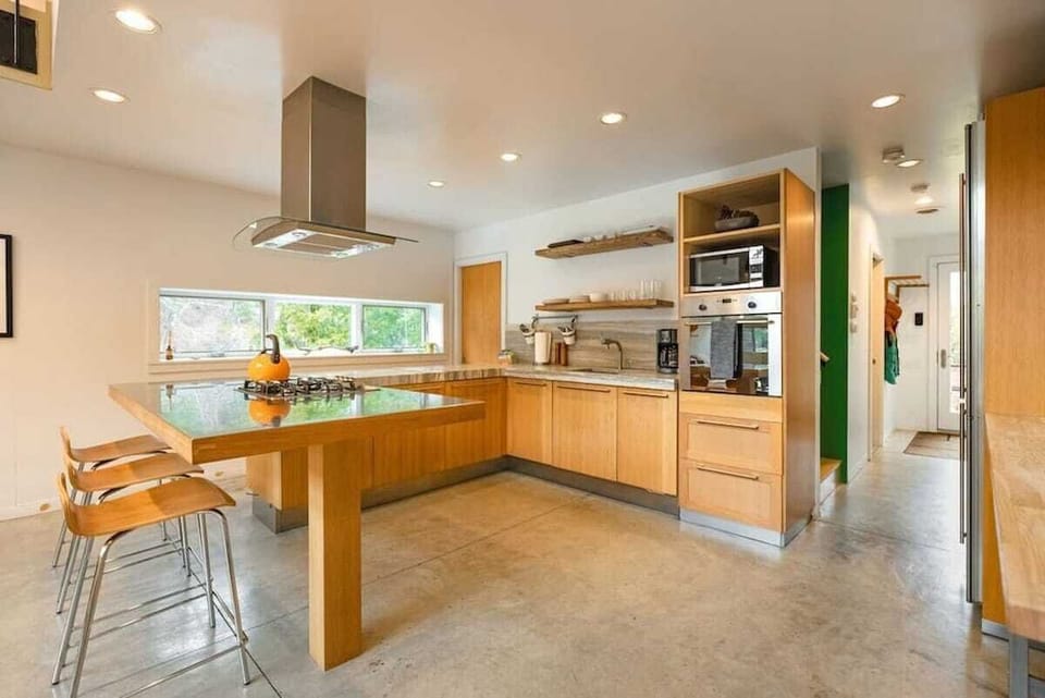 Our open-concept kitchen with oven, gas range,  microwave, coffee maker, bar seating and dining table.