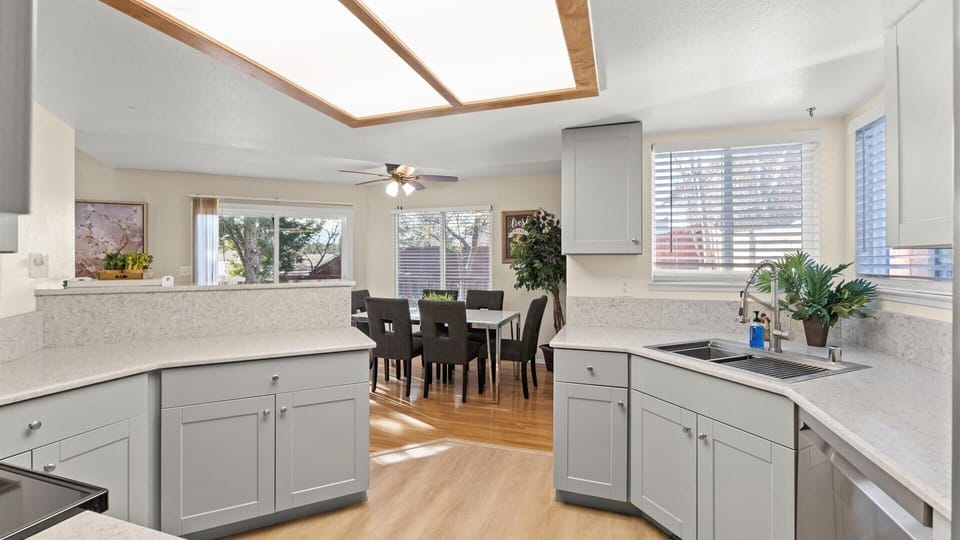 This open kitchen flows seamlessly into the dining area, offering plenty of room to prepare meals, share conversations, and enjoy time together in a bright, comfortable setting