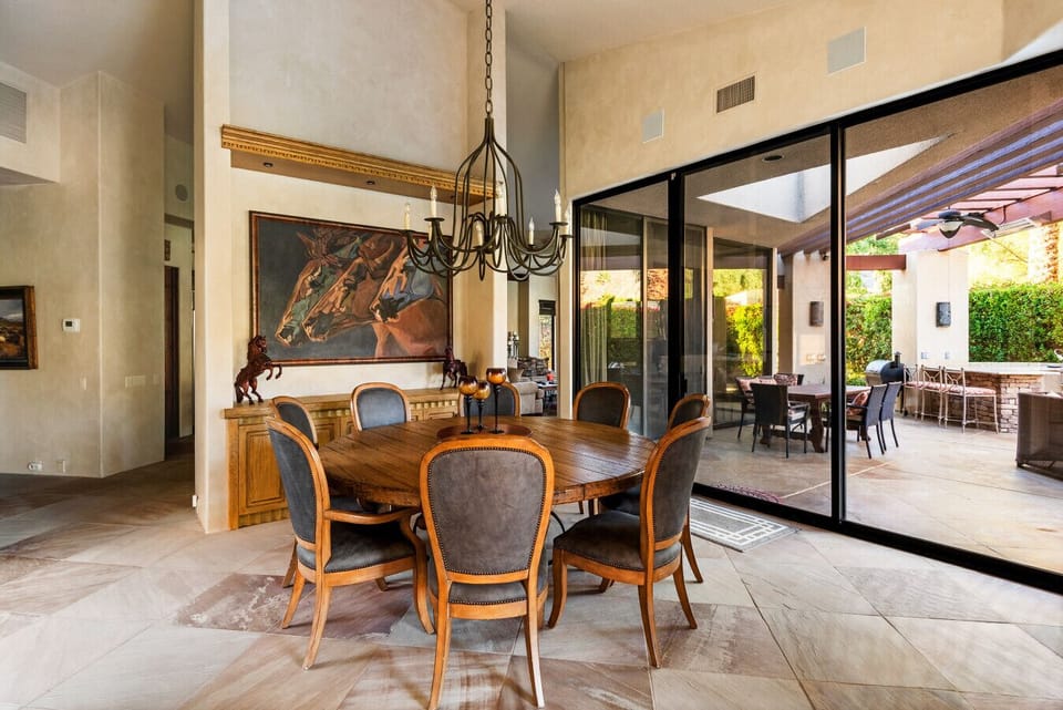 An elegant dining space with soaring ceilings and seamless indoor–outdoor views, designed for memorable gatherings and relaxed luxury.