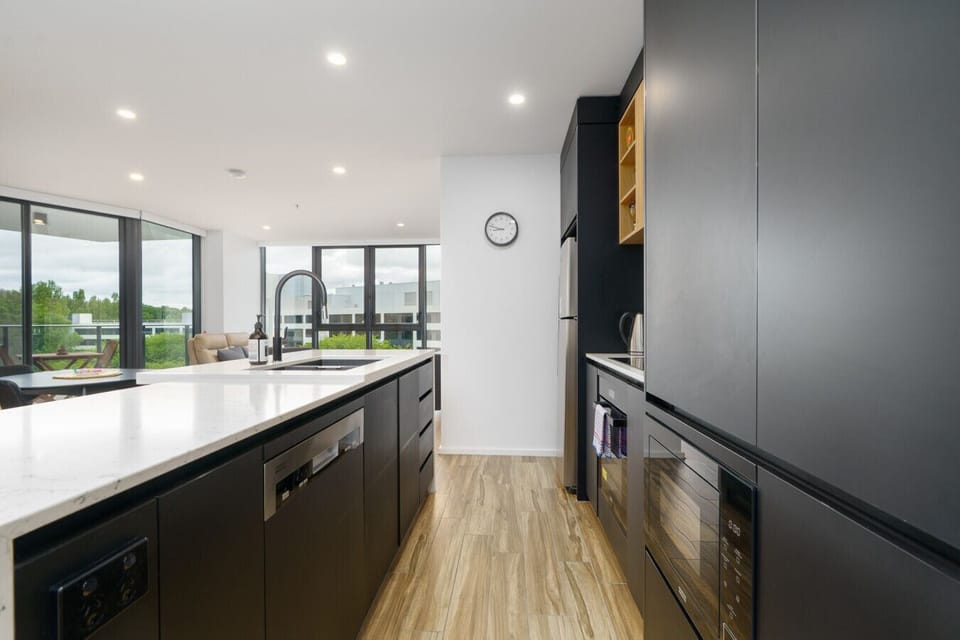 Experience the striking blend of matte finishes and warm textures in this elegant kitchen.