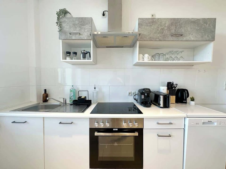 Die Küche verfügt über Besteck, Salz & Pfeffer, Schneidebretter, einen Kühlschrank einen Backofen. Es gibt eine Mikrowelle, zwei Herdplatten, einen Toaster sowie eine Kaffeemaschine und einen Wasserkocher etc.