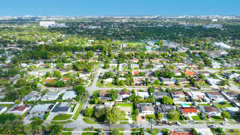This aerial photo highlights the property's location within a larger neighborhood and its proximity to a city skyline.