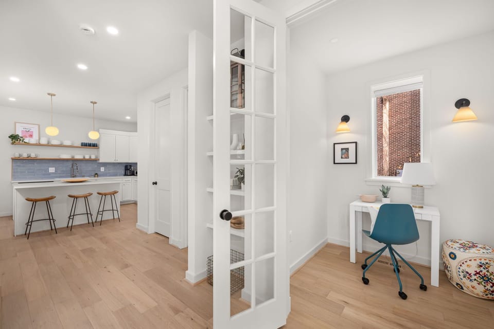 Office integrates seamlessly with main living space via elegant French doors