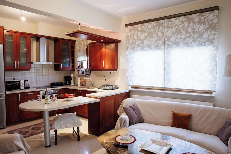 Bright open-plan kitchen and living area with cozy seating and warm wooden cabinetry.